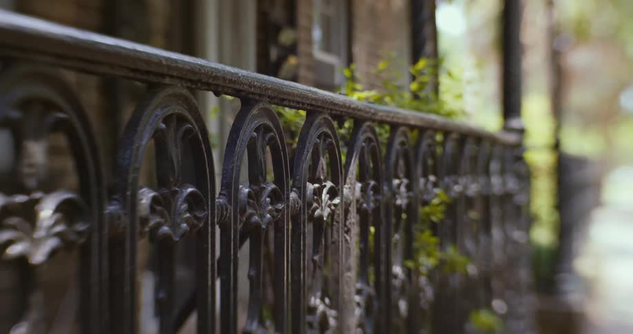 Close up of the decorated iron fence in the front porch of a house