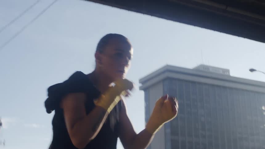 A woman is shadowboxing in the city