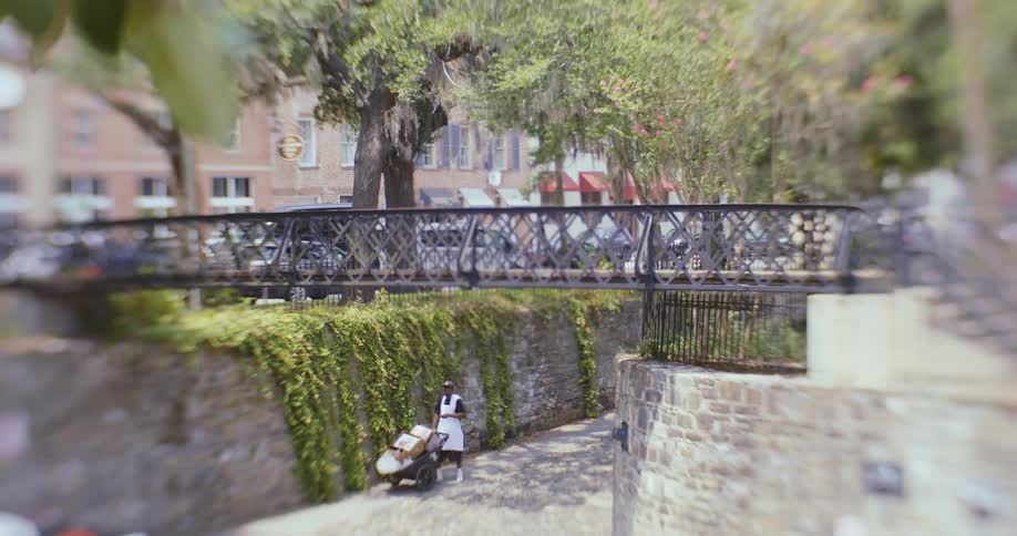 A person is pushing a carriage under the bridge
