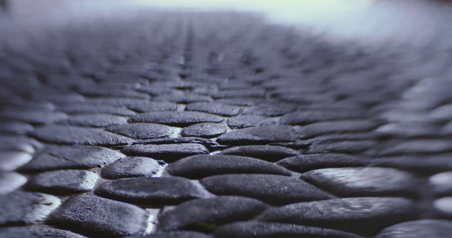 Close up of the stones on a cobblestone paved road at day time