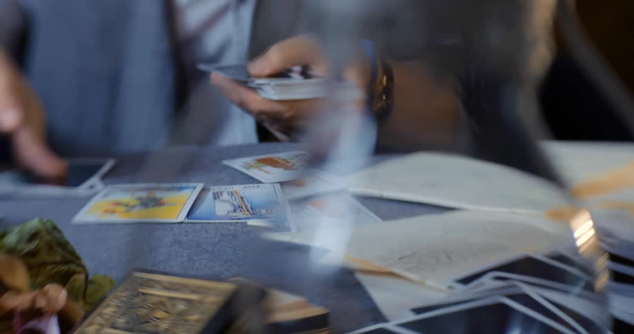 A woman lies cards down on a table