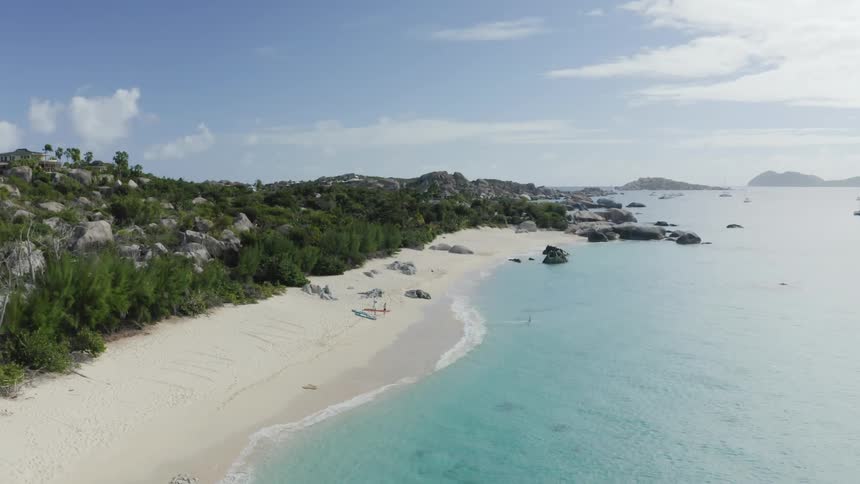Aerial of a white sand beach and clear blue water in the tropics