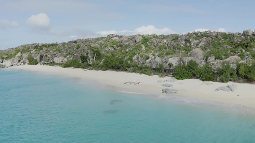 White sand beach next to a shore with clear blue water on an island at daytime