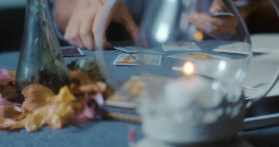 A man sits at a table gathering cards indoors