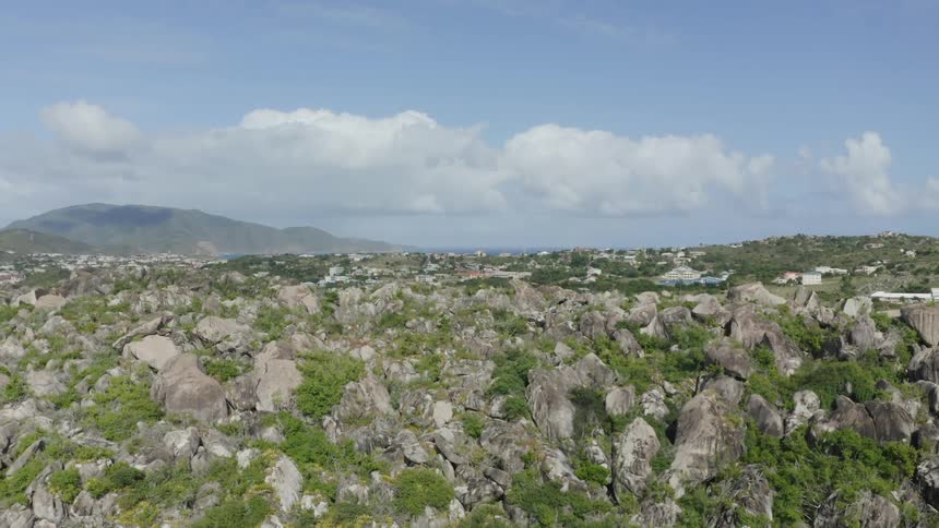 A landscape view of a hill with a skyline and coast in the distance