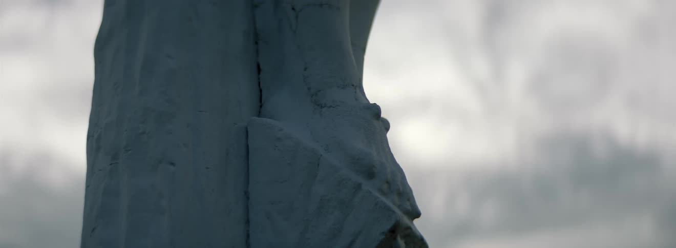 Close up of the feet of a crucifixion statue outdoors on an overcast day
