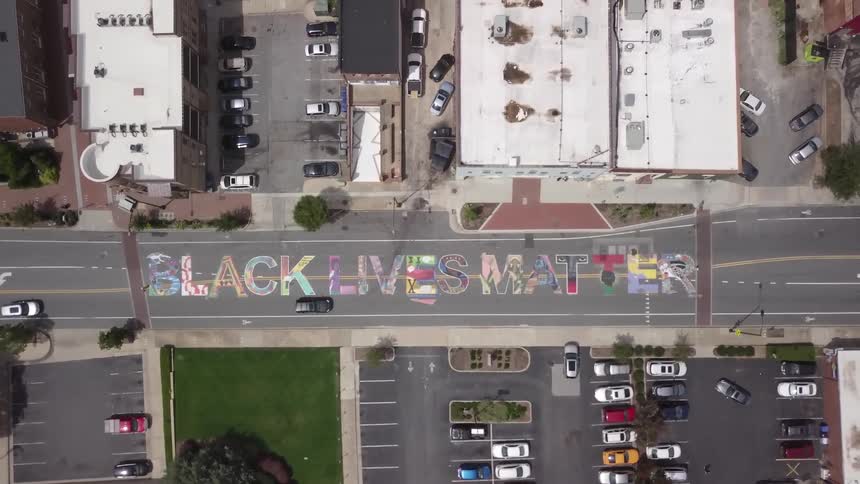 Black lives matter painting onto a street in a city
