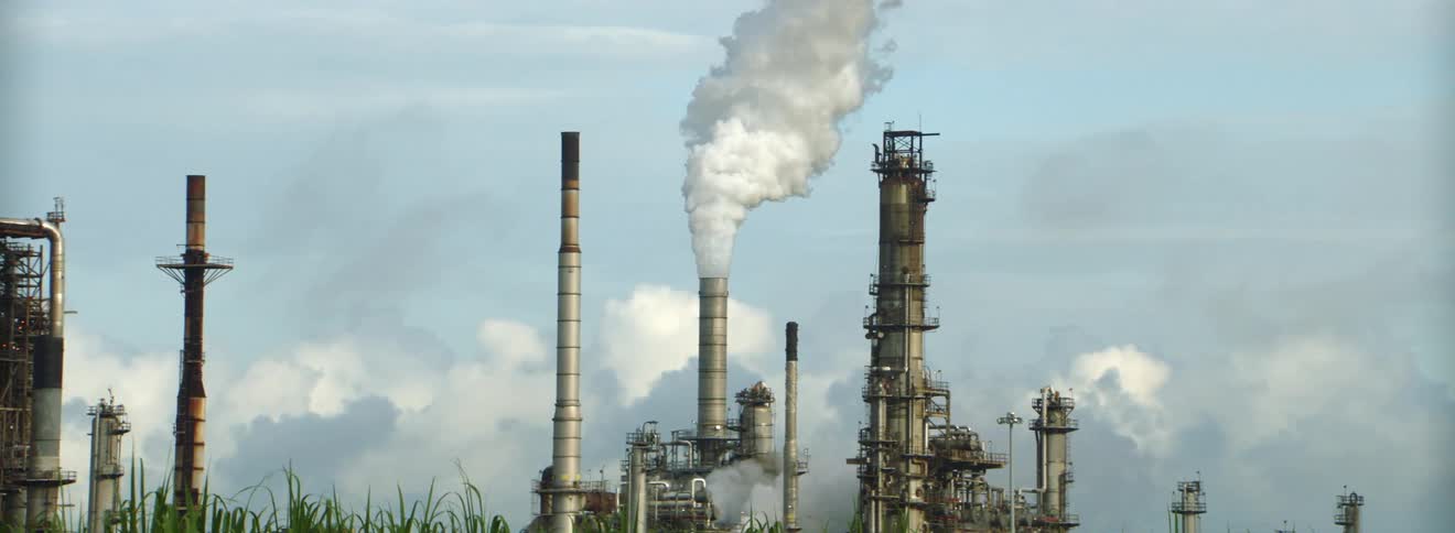Smoke emerging from a factory smokestack in the daytime