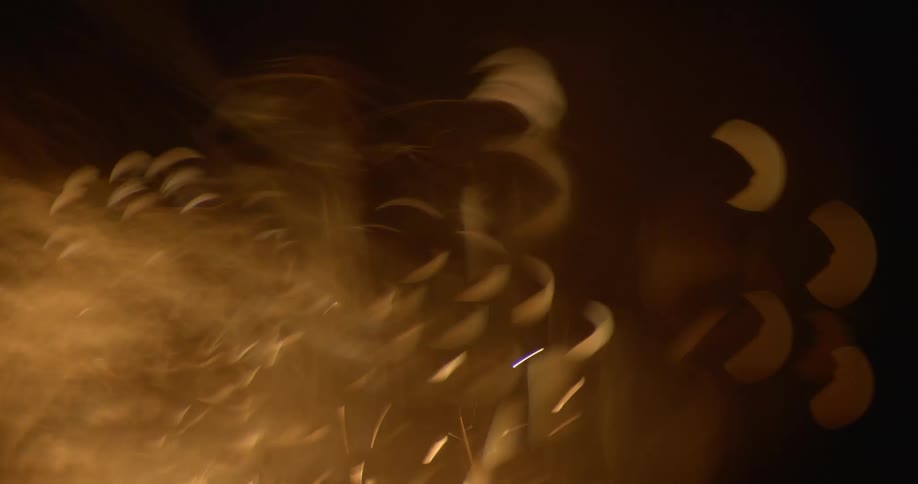 In the darkness a continuous flurry of small sparks are launched upwards