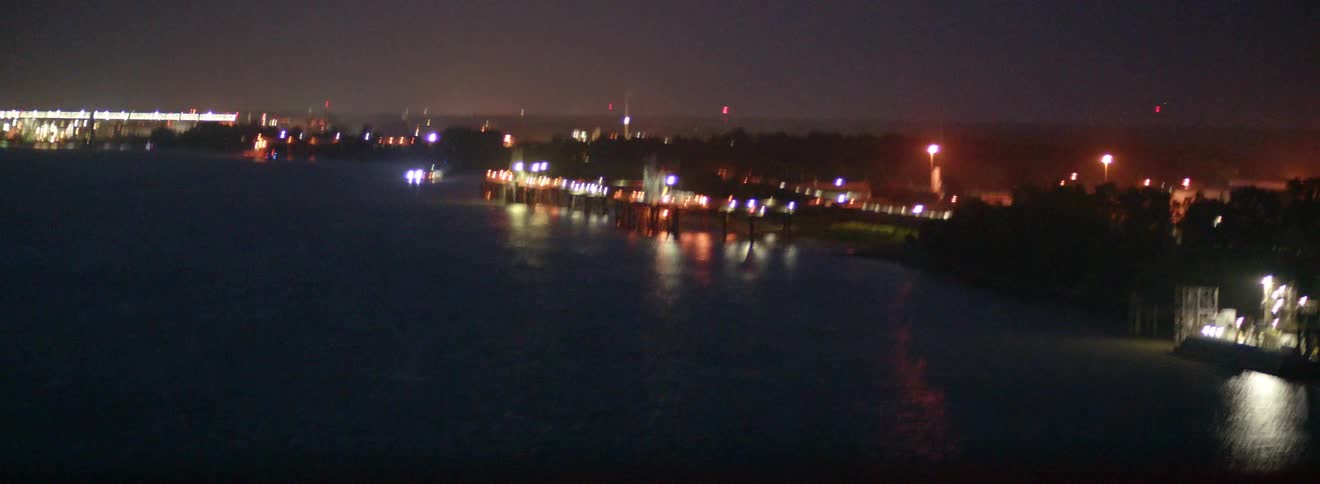 Shoreline of water with city and lights illuminated at night