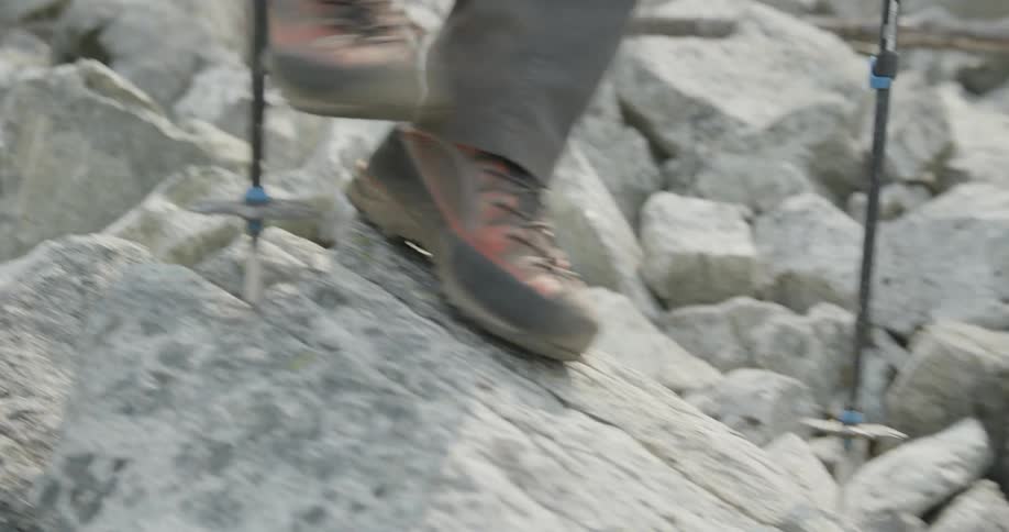 A person hikes over large rocks
