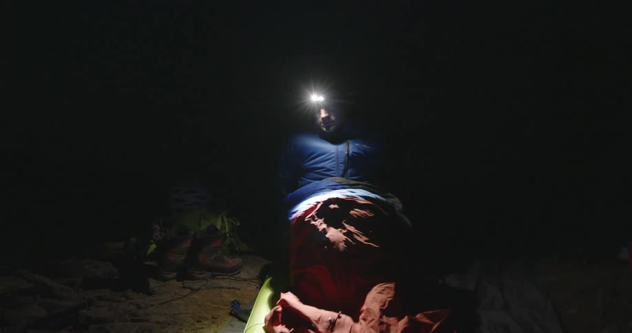 A man goes to bed in his sleeping bag