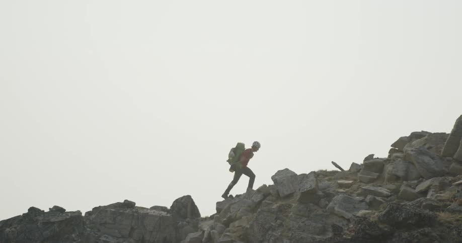 A man is rock climbing up a mountain