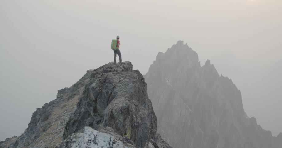 A man is climbing a mountain at dusk