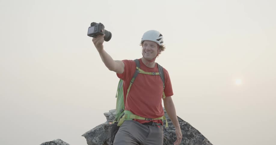 Taking a selfie with a photography camera near a large rock