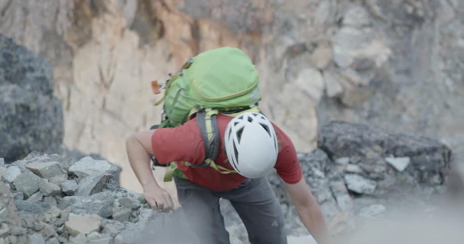 A man is rock climbing outdoors in the day
