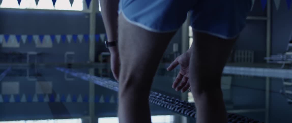 Swimmer standing on the edge of an indoors olympic pool