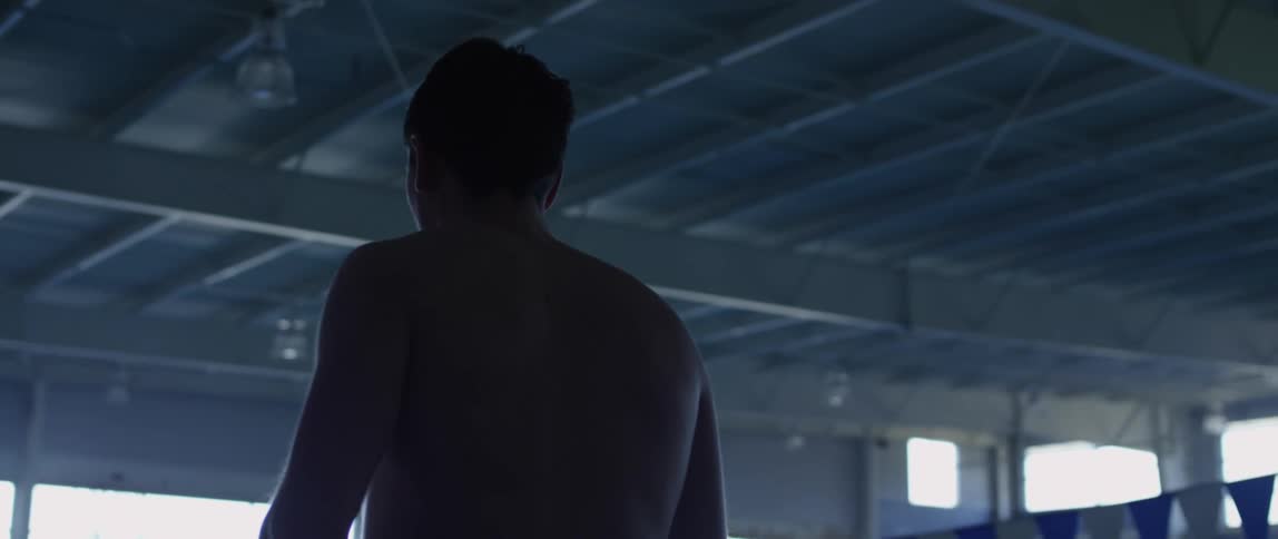 A man is walking inside a building during the day
