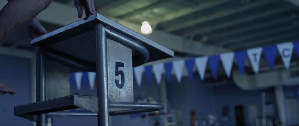 A swimmer climbs on to a starting block