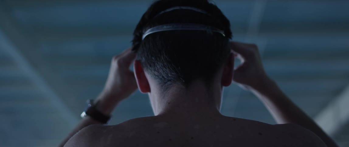 A swimmer takes off his goggles