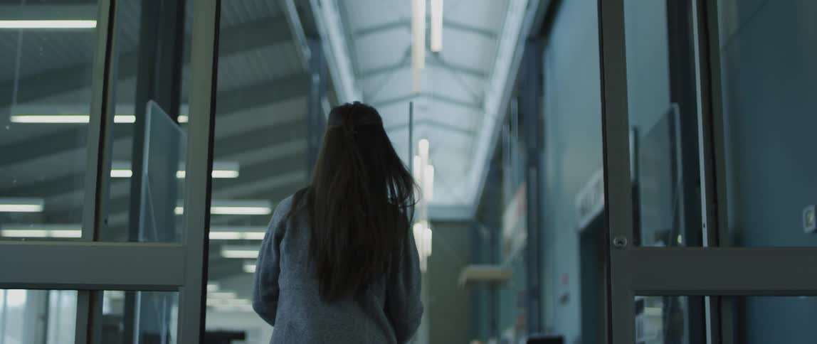 A woman is walking into a building