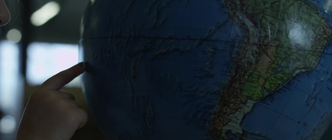 A child spins a globe with their finger