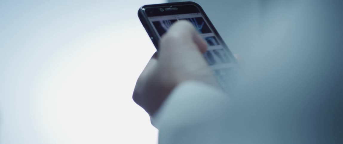Person with smartphone passes door with silhouetted figure