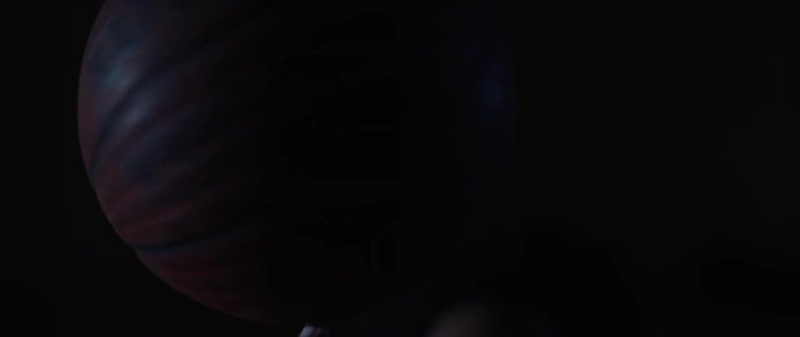 Man spinning a basketball on the fingers of his hand on a dark room