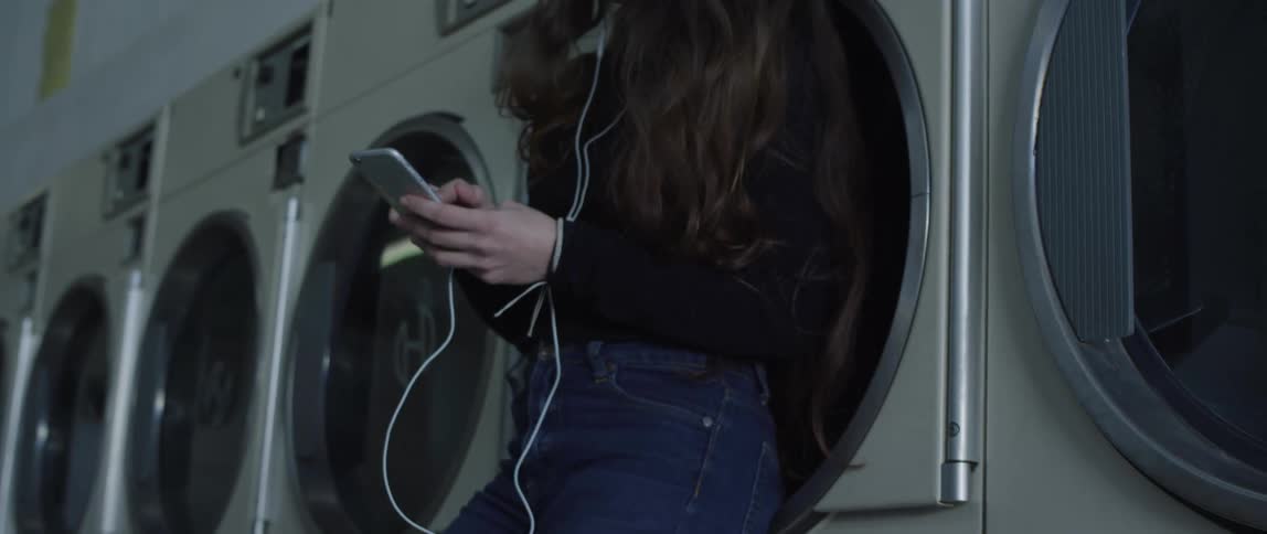 A woman standing in front of a set of laundry machines