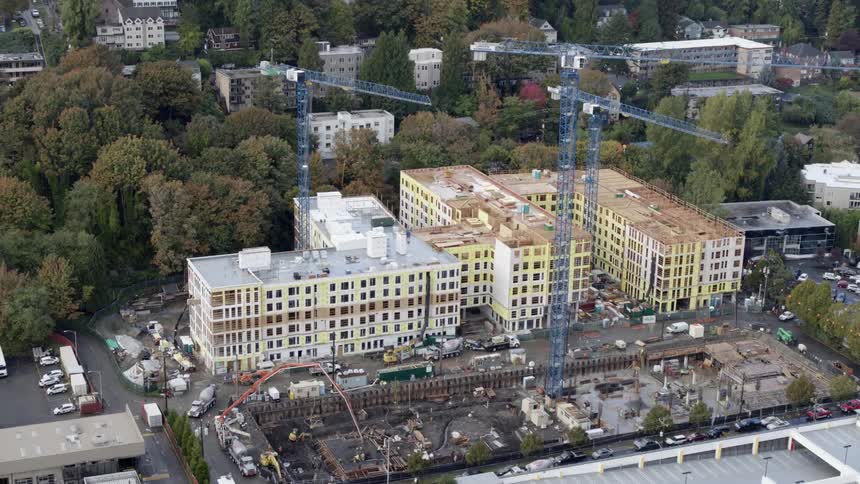 Aerial orbit of new condominiums and apartment buildings under construction in an urban neighborhood