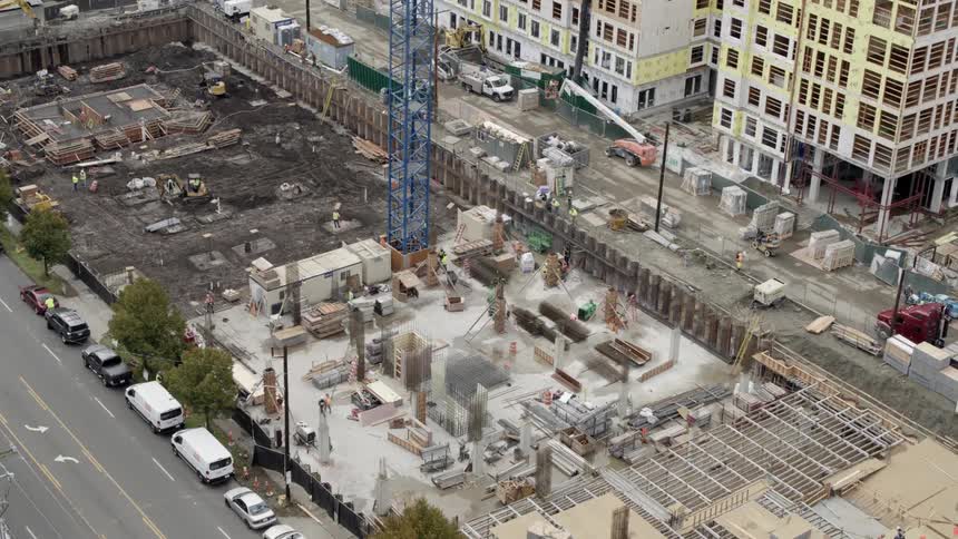 A city block being redeveloped with the construction of a new condo building complex