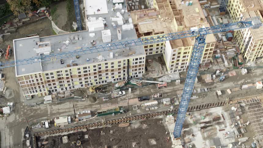 Birds eye view of multiple apartment buildings during various phases of construction