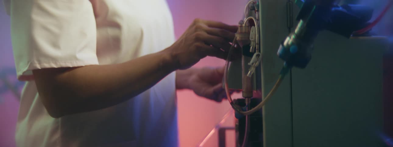 Nurse checking the settings of medical equipment in a colorful room