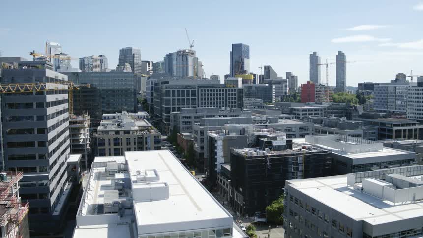 Traversing a downtown district with multiple construction projects and tower cranes along the skyline