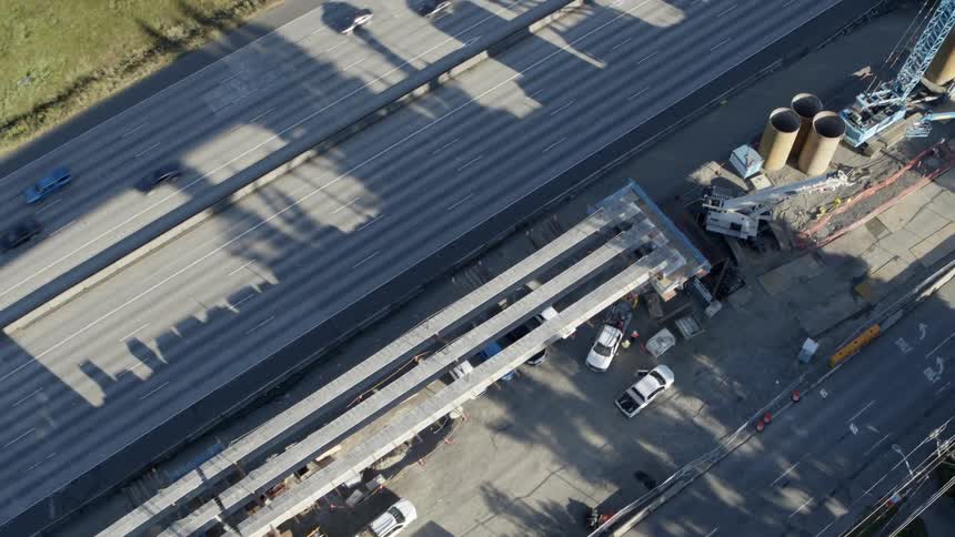 Birds eye view of ongoing construction for a new light rail transit system being built next to a highway