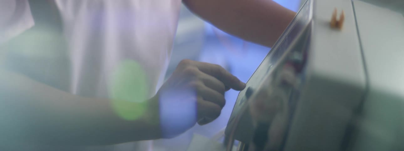 Nurse in a hospital room adjusting the settings on a piece of medical equipment