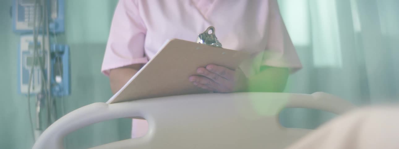 A nurse writing on a clipboard