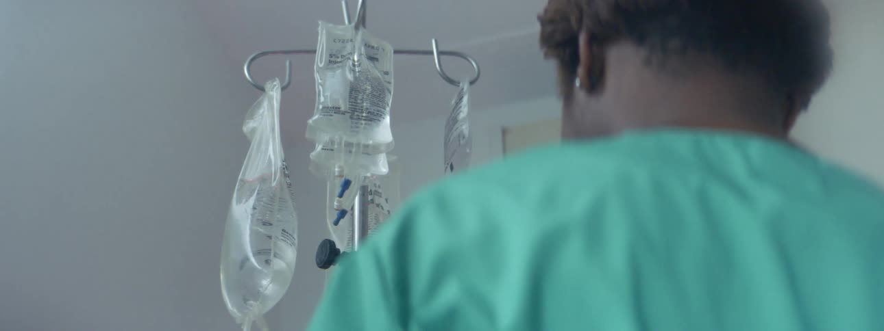 A doctor is hanging an iv bag
