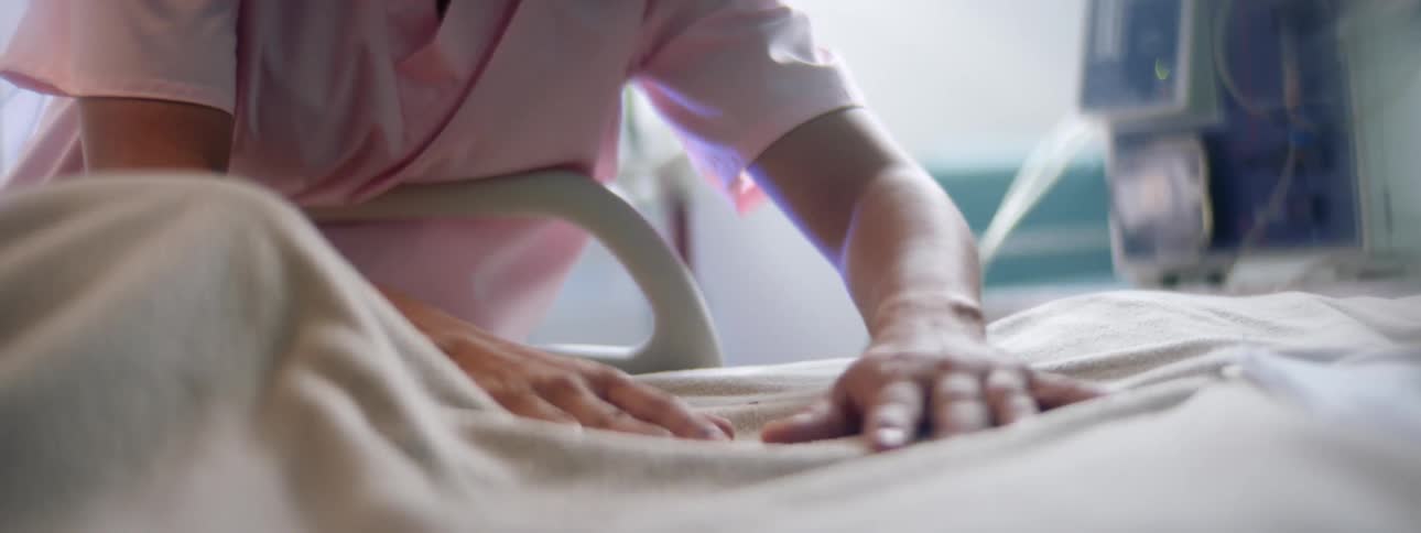 Nurse soothes patient lying in hospital bed