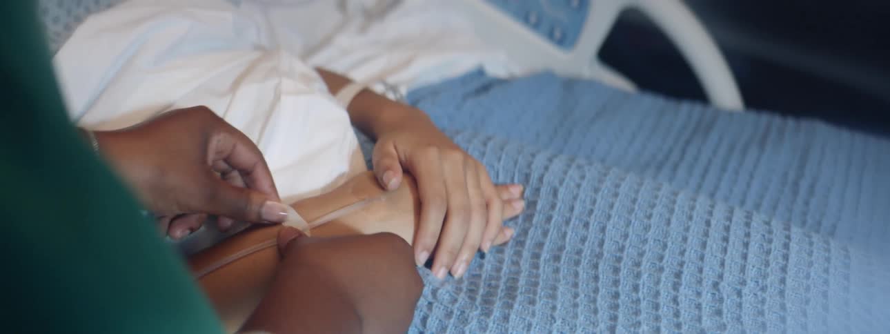 Nurse fixing an iv on a patients hand