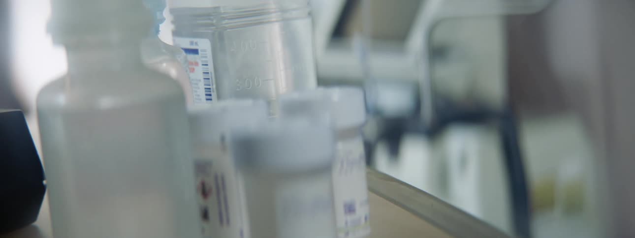Bottles of medicine and lab equipment on a counter in a hospital room