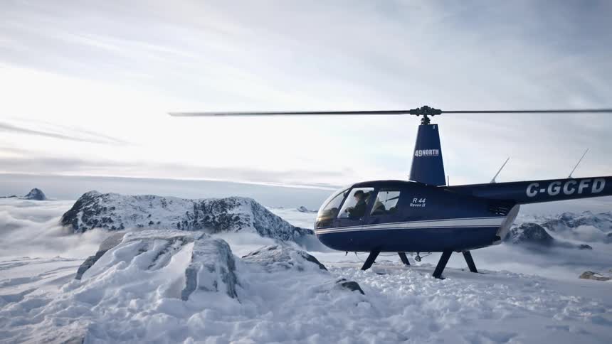 Helicopter on the top of a mountain in the snow at daytime