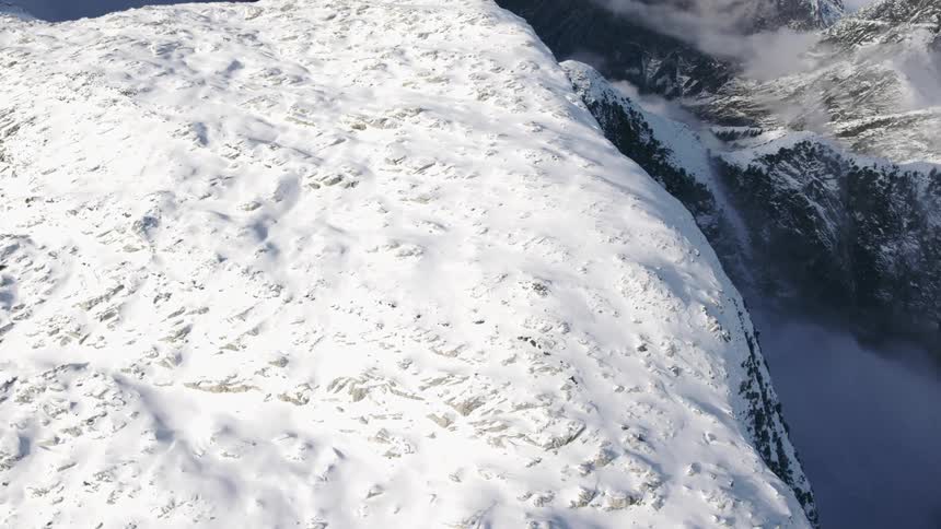 An aerial view of a snow covered mountain range