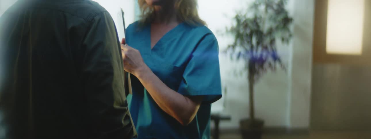 A nurse talks to a patient in a waiting room
