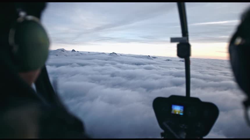 Two pilots flying an aircraft in the cloudy sky