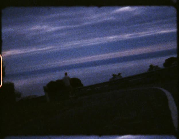 Person skateboarding down a path during dusk