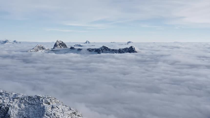 The peaks of a handful of mountains standout above a dense layer of clouds