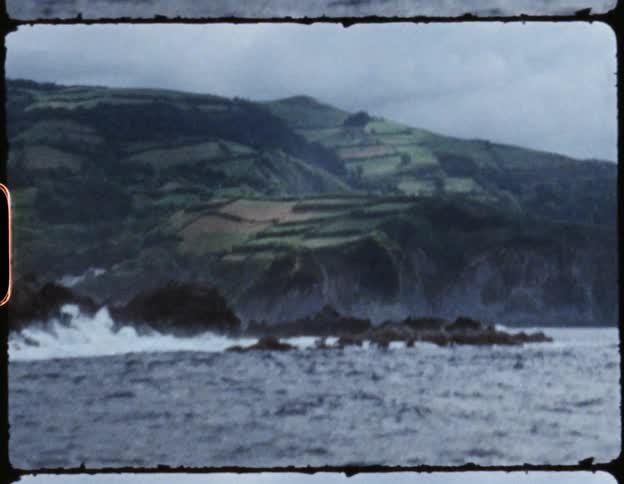 Waves crash and break against the rocky mountainous coastline