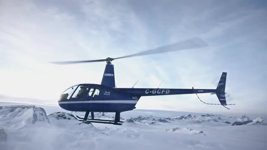 A helicopter landing on a snow covered mountain