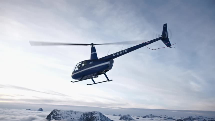 A helicopter takes off from a snowy area